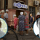 Ukrainian civilians queuing at post office with overlaid photos of war crimes investigators Dmytro Kovalchuk and Kristin Rosella