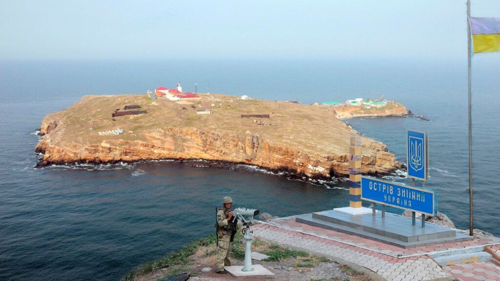 Ukrainian border guard with Snake Island in the Black Sea in the background