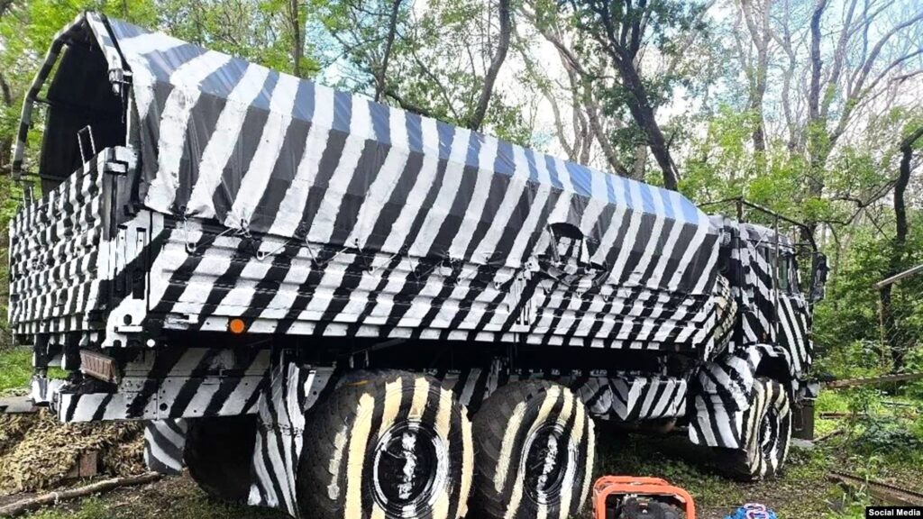 Russian military vehicle with zebra-like paint patterns in an attempt to disrupt AI-assisted drone targeting systems. Photo from social media, via RFE/RL.