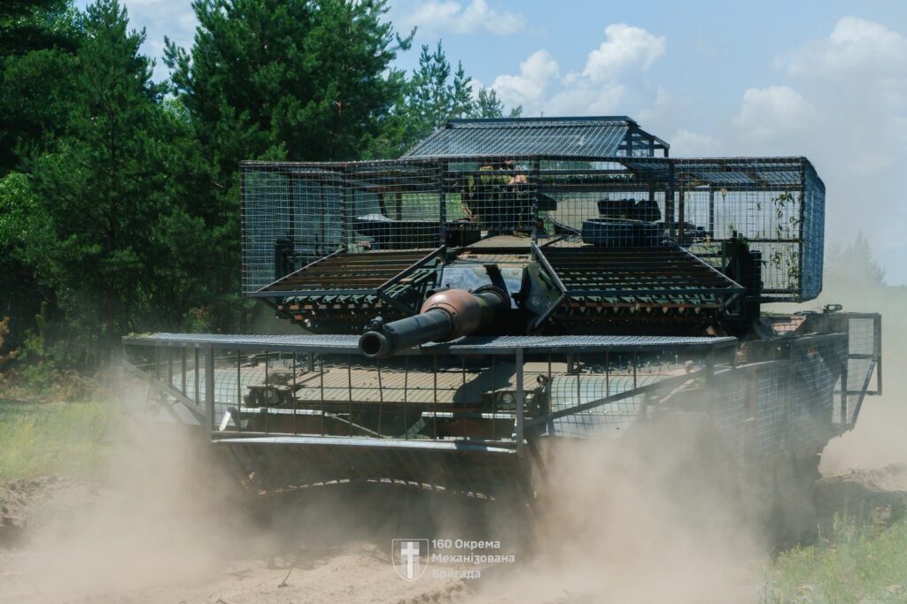 Ukrainian Abrams tank fitted with modular cage-style protection designed to counter FPV drone strikes on the front line, as crews adapt Western armor to modern battlefield threats. Photo: Ukraine’s 160th Separate Mechanized Brigade