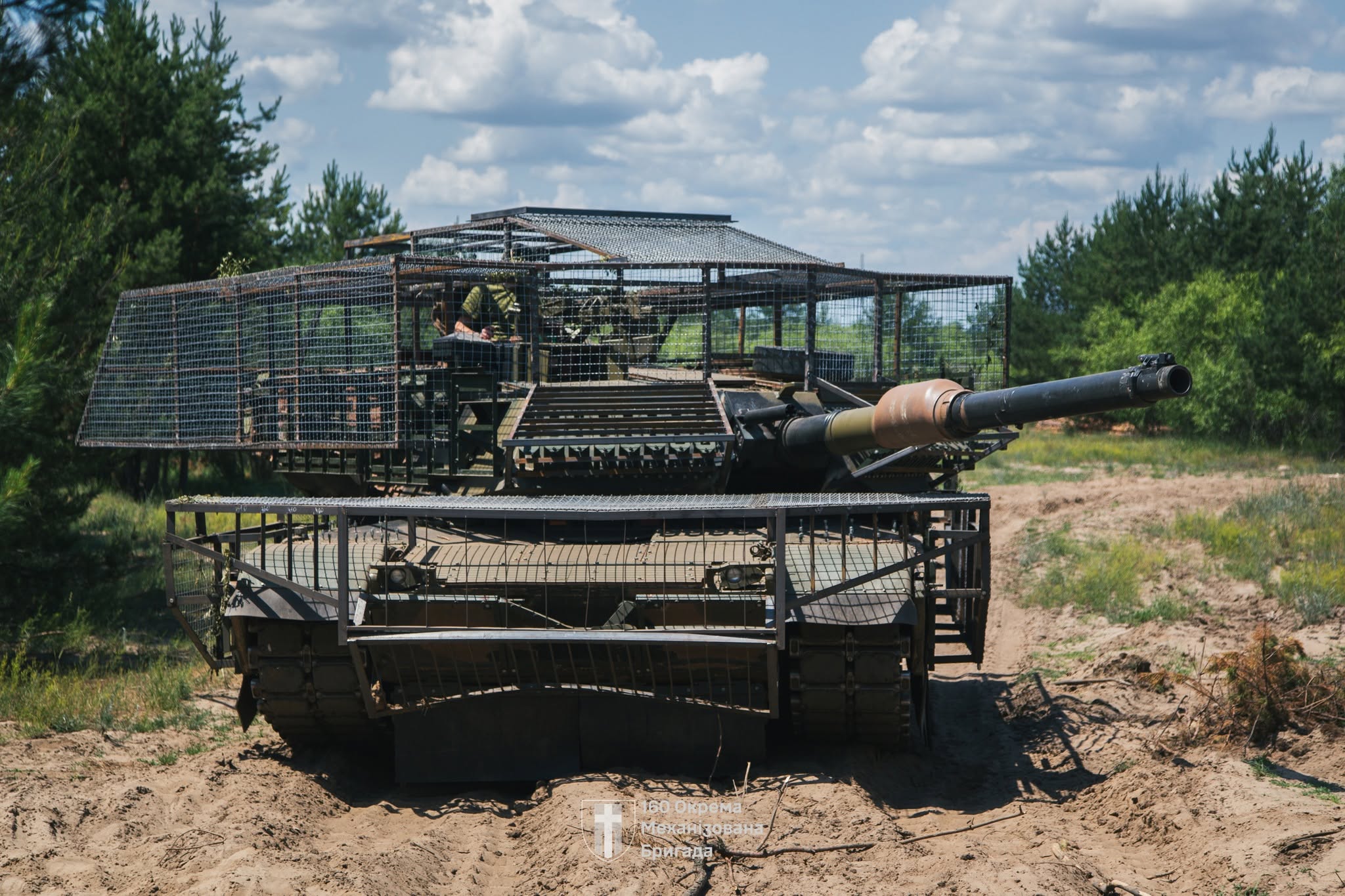 Ukrainian Abrams tank fitted with modular cage-style protection designed to counter FPV drone strikes on the front line, as crews adapt Western armor to modern battlefield threats. Photo: Ukraine’s 160th Separate Mechanized Brigade