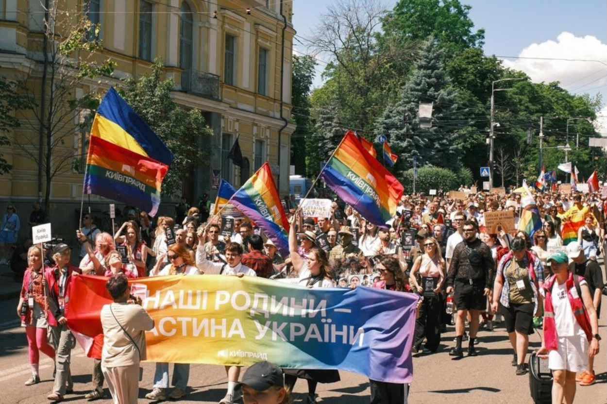 Banneret lyder: «Våre familier er en del av Ukraina.» Deltakerne deltar i KyivPride-marsjen i sentrale Kyiv 21. juni 2026. Foto: KyivPride
