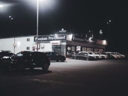 British car lot at night with many used cars for sale
