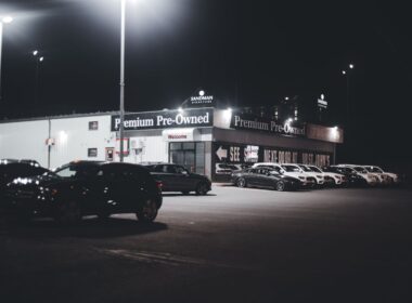 British car lot at night with many used cars for sale