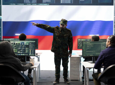 Russian army officer supervising cyber attacks on state networks, spreading misinformation and fake news around Europe during hybrid war. Military personnel works on scams and hacking. Russian disinformation misinformation cyber campaign Russian information warfare