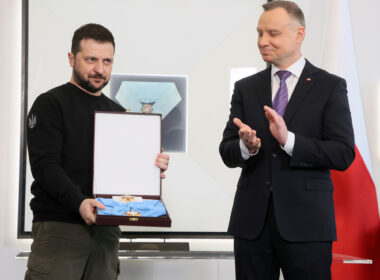 Volodymyr Zelenskyy holds the Order of the White Eagle in its case as Polish President Andrzej Duda applauds at the Presidential Palace in Warsaw, April 2023