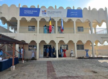 Beige two-story building with arched arcades and a blue 