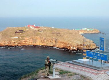 Ukrainian border guard with Snake Island in the Black Sea in the background