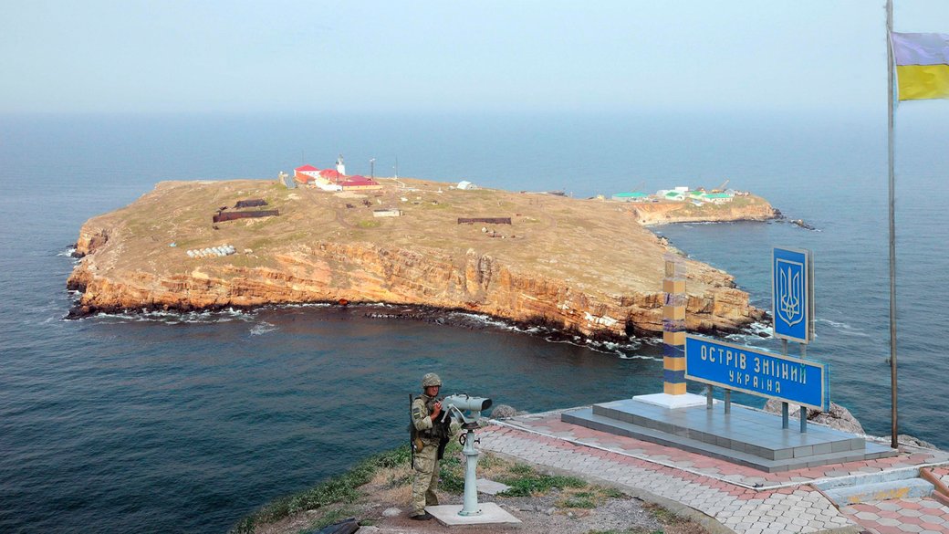 Ukrainian border guard with Snake Island in the Black Sea in the background