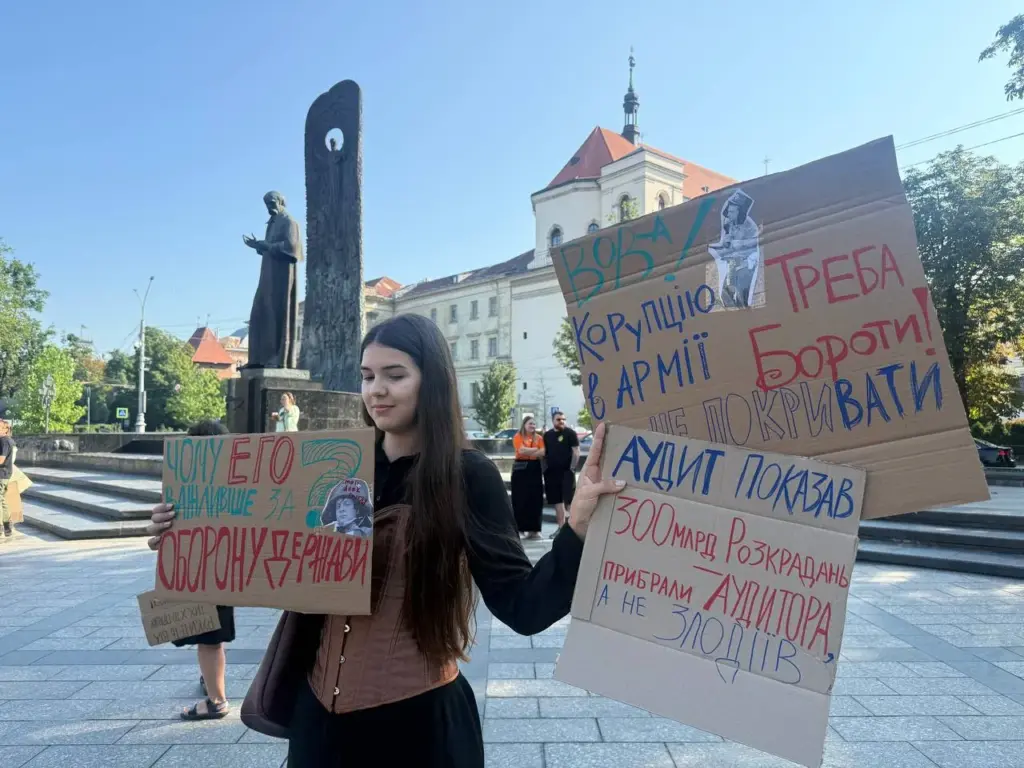 A protester in Lviv holds a placard reading: ""The audit showed 300 billion in theft. They removed the auditor, not the thieves."Photo: Suspilne