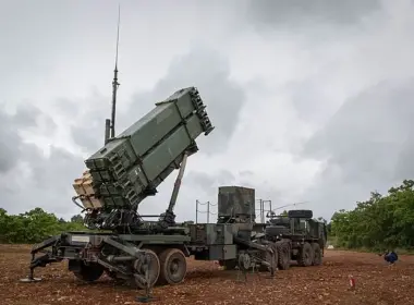A Patriot air defense launcher raised into firing position on a military trailer.