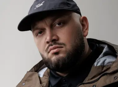Ukrainian-American rapper Kyivstoner wearing a black cap and dark jacket.