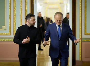 Ukrainian President Volodymyr Zelenskyy walks beside Polish Prime Minister Donald Tusk in an ornate government building.