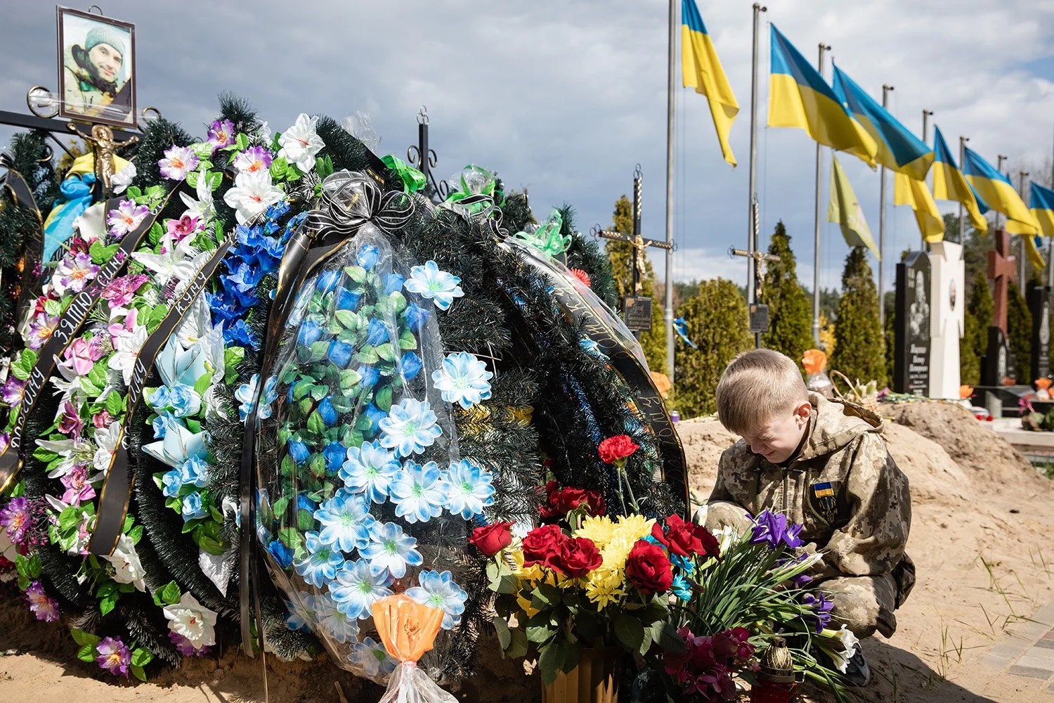A child cries at a grave in Irpin after its liberation from Russian occupation. 1 May 2022. Photo: Mykhailo Palinchak