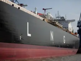 Large LNG tanker docked beside port cranes, illustrating Russian LNG imports to Belgium.