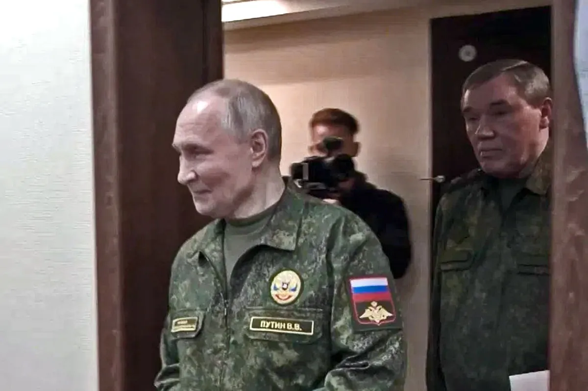 Vladimir Putin walks through a doorway in a military uniform, followed by Russian Chief of the General Staff Valery Gerasimov.