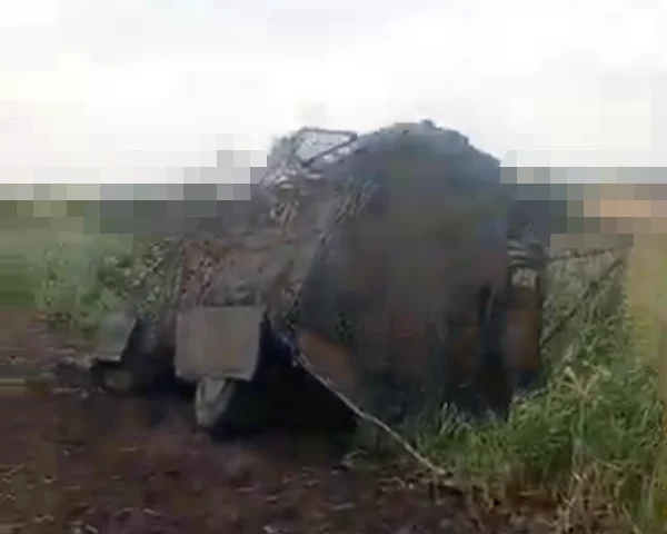 A damaged armored vehicle in a field.