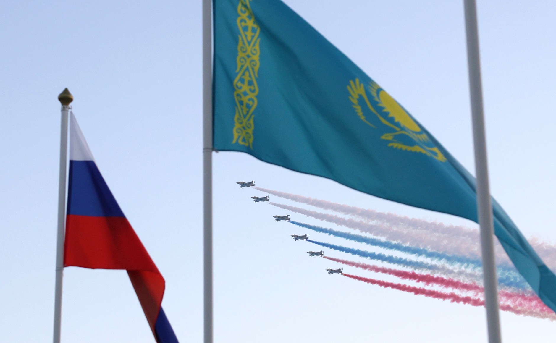 Russian and Kazakh flags fly as plane contrails form the Russian tricolour above Astana, Kazakhstan, 27 November 2024. Photo via Wikimedia Commons